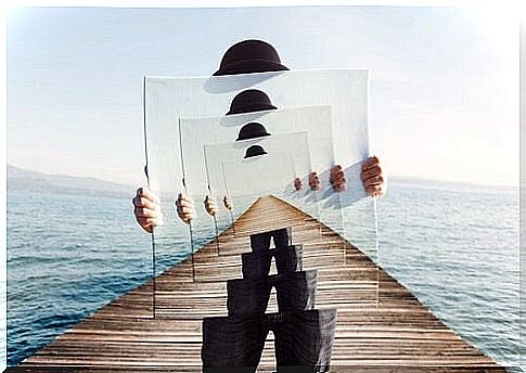 Man holding pictures of himself on a bridge