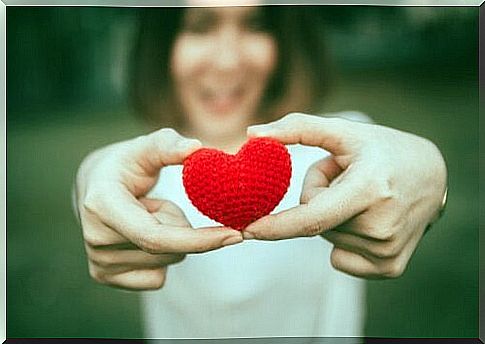 Woman holding heart in her hands and smiling