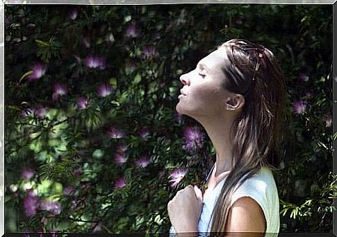 Woman breathing intensely in front of flowers