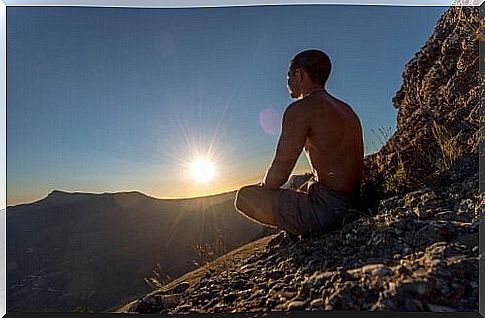 Meditating man on rock