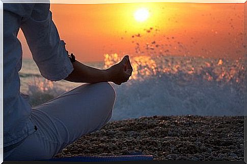 Man meditates in front of waves