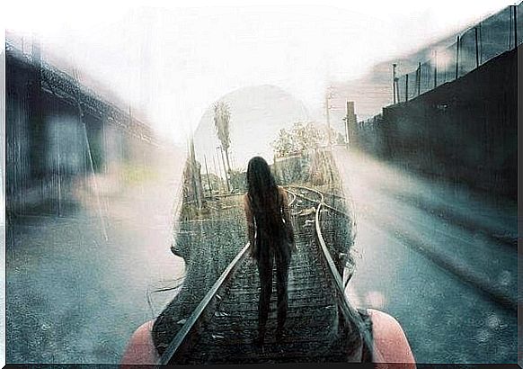 A girl walks on train tracks