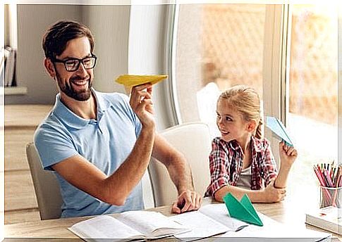 Father and daughter playing with paper