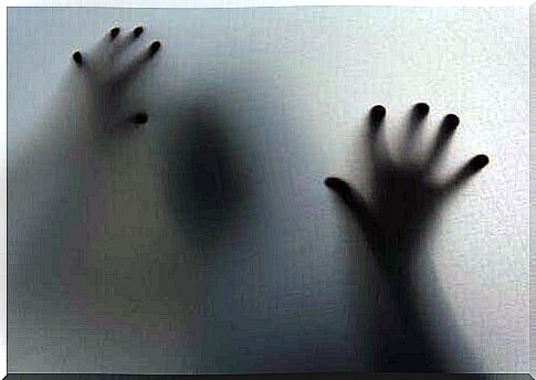 Shadow of person with hands on window is plagued by epidemic of anxiety