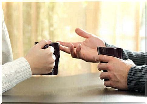 People talk to each other, which can be seen on hands holding coffee cups facing each other