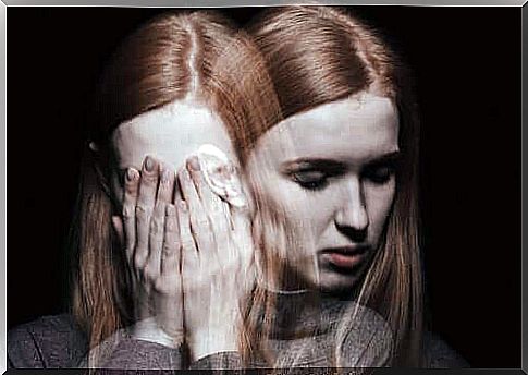 Woman with hands in front of face experiencing schizophrenia