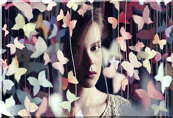 Woman behind curtain of butterflies