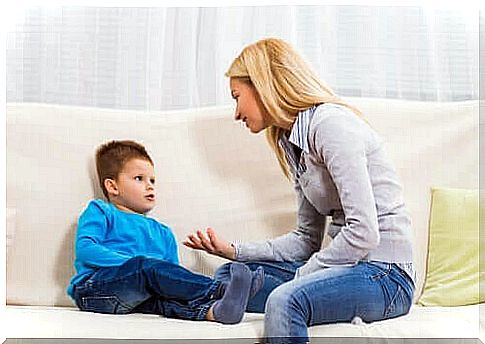 Woman talking to boy on sofa