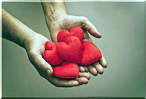 A pair of hands holding a pile of hearts