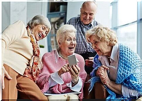 Older people having fun over smartphone