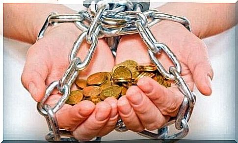 person with hands in chains spends more money than he has