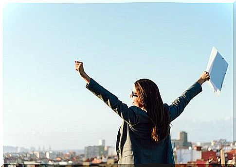 Woman with arms over head possesses workplace commitment