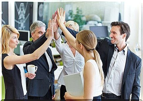 Colleagues give common high five due to workplace commitment